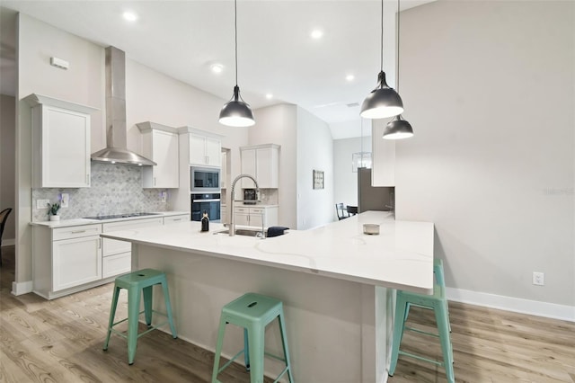 13334 Oldenburg Dr, Hudson, FL 34667 - kitchen with oven, wall chimney exhaust hood, stainless steel microwave, a peninsula, and a kitchen breakfast bar