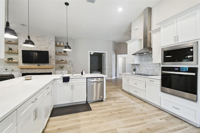 13334 Oldenburg Dr, Hudson, FL 34667 - kitchen featuring appliances with stainless steel finishes, wall chimney range hood, a sink, backsplash, and white cabinets