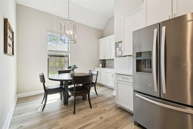 13334 Oldenburg Dr, Hudson, FL 34667 - dining room with a chandelier, light wood finished floors, vaulted ceiling, and baseboards