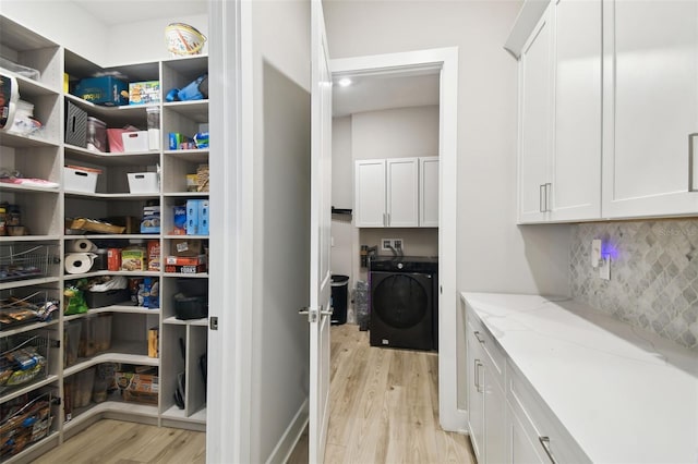 13334 Oldenburg Dr, Hudson, FL 34667 - washroom featuring washer / clothes dryer, cabinet space, and light wood finished floors