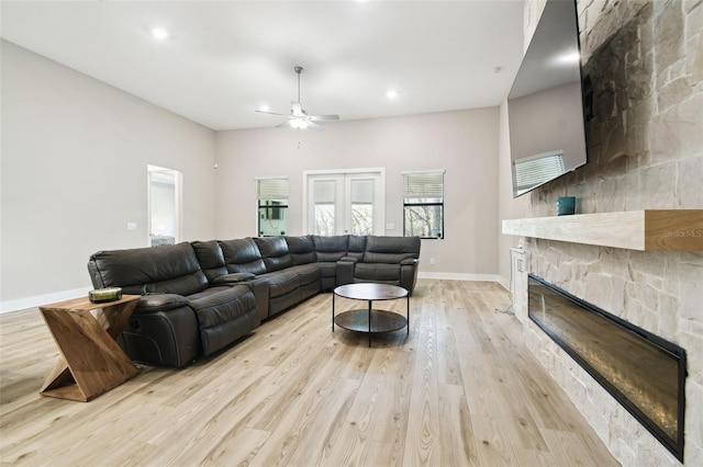 13334 Oldenburg Dr, Hudson, FL 34667 - living room featuring a stone fireplace, light wood-style flooring, a ceiling fan, baseboards, and recessed lighting