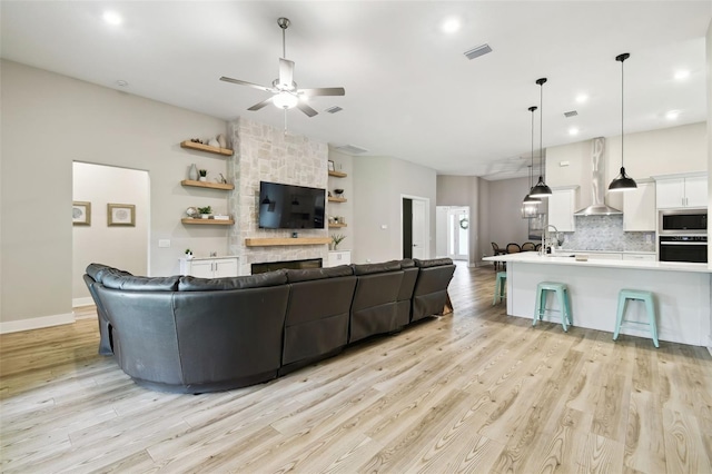 13334 Oldenburg Dr, Hudson, FL 34667 - living area featuring a ceiling fan, light wood-style floors, a stone fireplace, baseboards, and recessed lighting