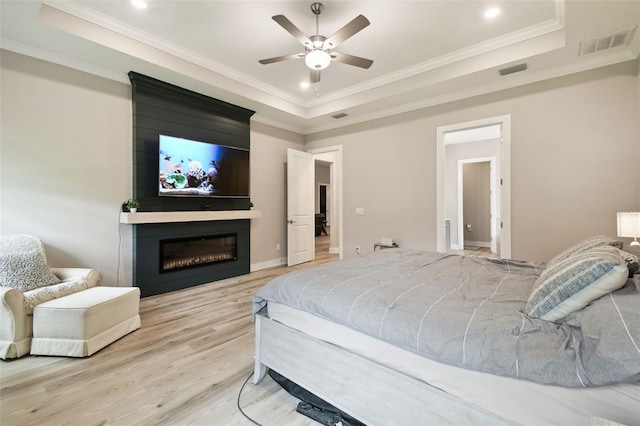 13334 Oldenburg Dr, Hudson, FL 34667 - bedroom with a tray ceiling, light wood-type flooring, a large fireplace, ornamental molding, and recessed lighting