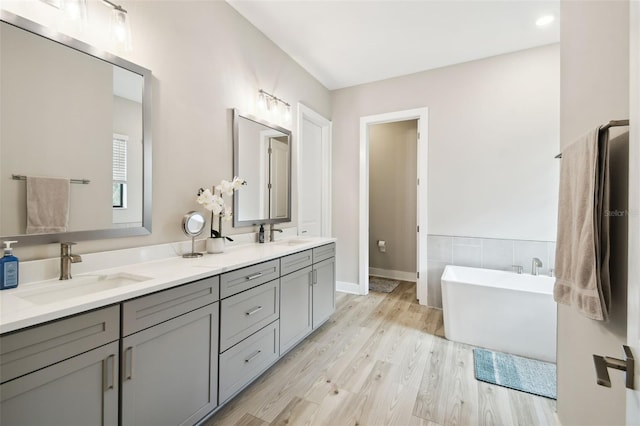 13334 Oldenburg Dr, Hudson, FL 34667 - bathroom with double vanity, a soaking tub, and wood finished floors