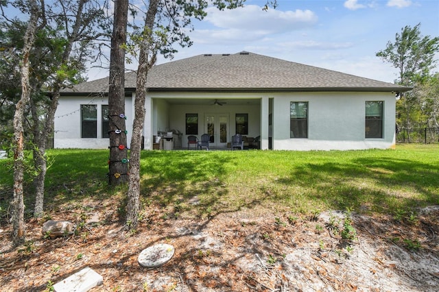 13334 Oldenburg Dr, Hudson, FL 34667 - rear view of property with stucco siding, french doors, and a lawn