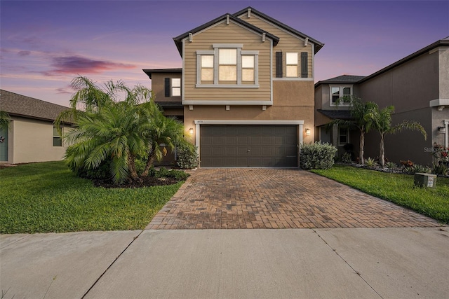 8719 Winning Fields Rd, New Port Richey, FL 34655 - traditional home featuring decorative driveway, an attached garage, stucco siding, and a yard