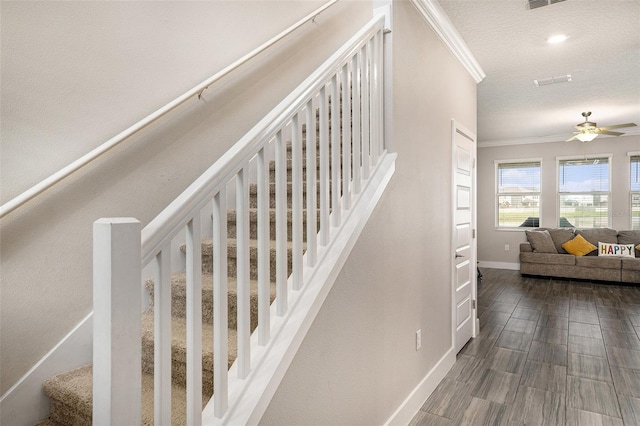 8719 Winning Fields Rd, New Port Richey, FL 34655 - stairs featuring ornamental molding, baseboards, a ceiling fan, a textured ceiling, and wood finished floors