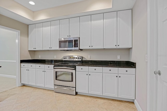 16137 Churchview Dr, Lithia, FL 33547 - kitchen with stainless steel appliances, white cabinetry, dark stone countertops, baseboards, and recessed lighting