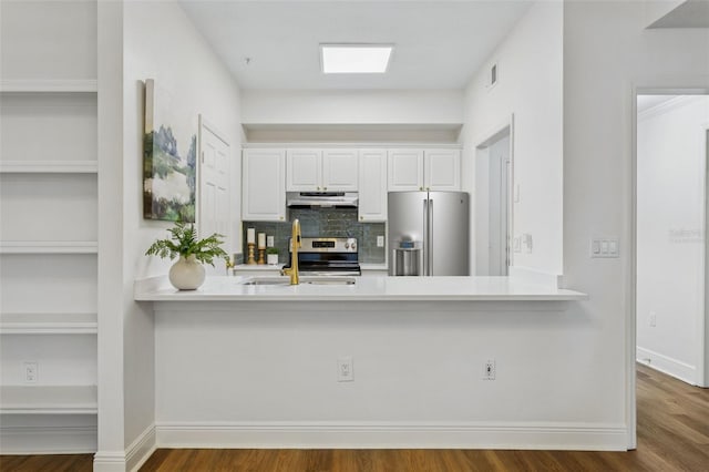 800 S Dakota Ave Unit 204, Tampa, FL 33606 - kitchen featuring stainless steel appliances, under cabinet range hood, a peninsula, decorative backsplash, and white cabinets