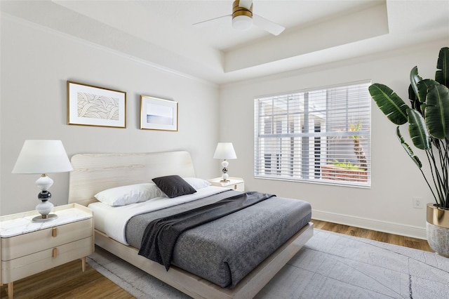 800 S Dakota Ave Unit 204, Tampa, FL 33606 - bedroom featuring a tray ceiling, wood finished floors, ceiling fan, ornamental molding, and baseboards