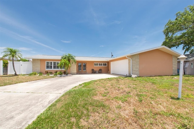 9591 Commodore Dr, Seminole, FL 33776 - single story home with concrete driveway, a garage, french doors, stone siding, and stucco siding