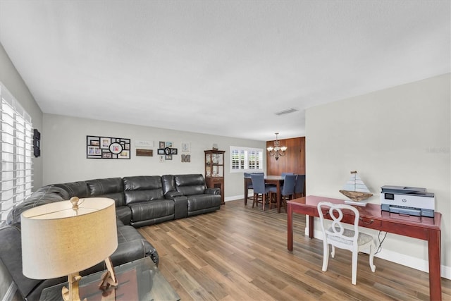 9591 Commodore Dr, Seminole, FL 33776 - living room with a chandelier, wood finished floors, and baseboards
