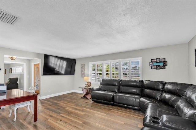 9591 Commodore Dr, Seminole, FL 33776 - living room featuring wood finished floors, a textured ceiling, and baseboards