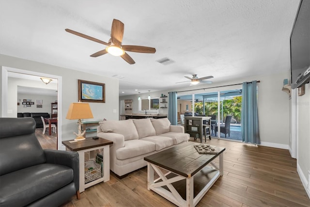 9591 Commodore Dr, Seminole, FL 33776 - living room featuring ceiling fan, baseboards, and wood finished floors