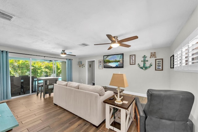 9591 Commodore Dr, Seminole, FL 33776 - living room featuring ceiling fan, wood finished floors, and baseboards