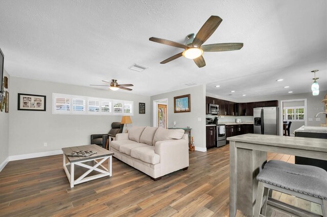 9591 Commodore Dr, Seminole, FL 33776 - living room with a ceiling fan, baseboards, dark wood-type flooring, recessed lighting, and a textured ceiling