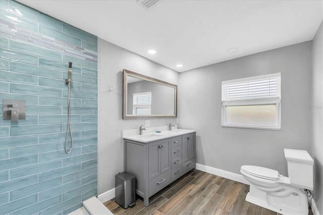 9591 Commodore Dr, Seminole, FL 33776 - full bath with baseboards, toilet, wood finish floors, double vanity, and recessed lighting