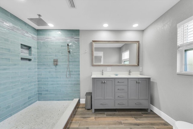 9591 Commodore Dr, Seminole, FL 33776 - bathroom with double vanity, wood finish floors, walk in shower, toilet, and recessed lighting