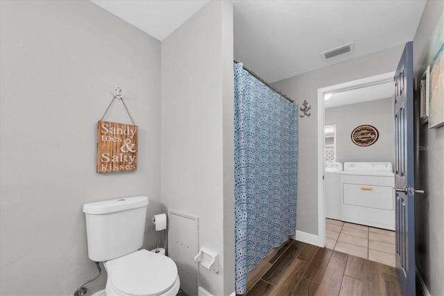 9591 Commodore Dr, Seminole, FL 33776 - full bath featuring separate washer and dryer, toilet, wood finished floors, a shower with shower curtain, and baseboards
