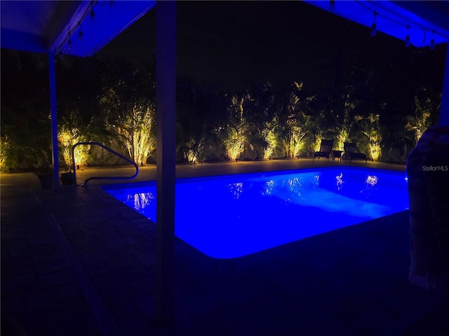 9591 Commodore Dr, Seminole, FL 33776 - pool at night featuring an outdoor pool