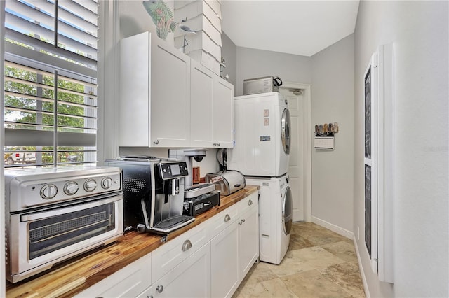 1817 Piccadilly Cir, Cape Coral, FL 33991 - kitchen with stacked washer / dryer, butcher block counters, white cabinetry, and baseboards
