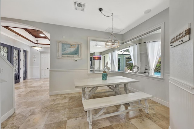 1817 Piccadilly Cir, Cape Coral, FL 33991 - dining room featuring arched walkways, a wainscoted wall, light stone finish floors, and a chandelier