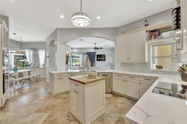 1817 Piccadilly Cir, Cape Coral, FL 33991 - kitchen featuring stainless steel dishwasher, arched walkways, a peninsula, a ceiling fan, and tasteful backsplash