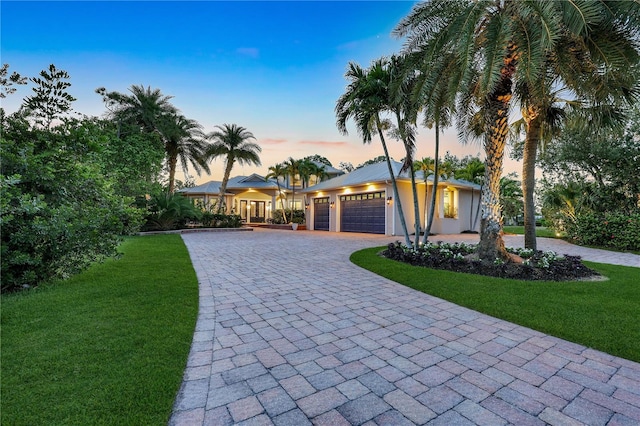 1817 Piccadilly Cir, Cape Coral, FL 33991 - view of front of house with a yard, an attached garage, and curved driveway