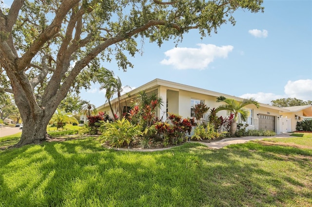 3966 High Bluff Dr, Largo, FL 33770 - view of front of house with stucco siding, an attached garage, and a front lawn