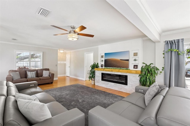 3966 High Bluff Dr, Largo, FL 33770 - living area featuring light wood-type flooring, a ceiling fan, crown molding, baseboards, and a glass covered fireplace