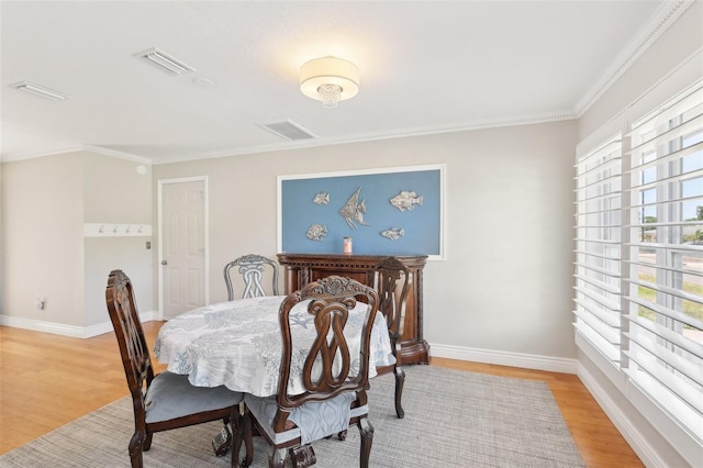 3966 High Bluff Dr, Largo, FL 33770 - dining room with light wood-style flooring, crown molding, and baseboards