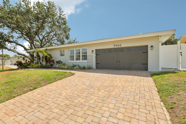 3966 High Bluff Dr, Largo, FL 33770 - ranch-style home with stucco siding, decorative driveway, and a garage