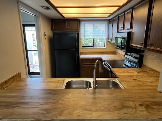 4309 Cedar Grove St, Holiday, FL 34691 - kitchen featuring freestanding refrigerator, stainless steel range with electric stovetop, butcher block countertops, a sink, and dark brown cabinetry