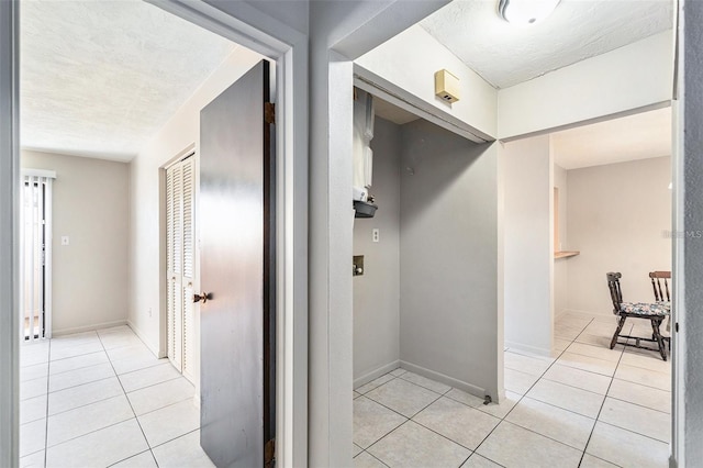 4309 Cedar Grove St, Holiday, FL 34691 - hallway with light tile patterned floors, a textured ceiling, and baseboards