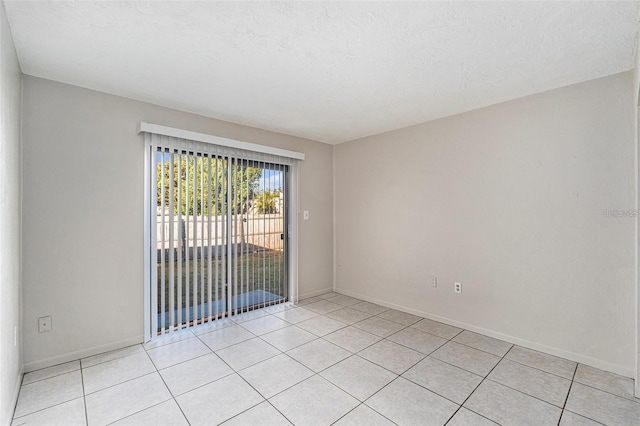 4309 Cedar Grove St, Holiday, FL 34691 - empty room featuring light tile patterned floors, baseboards, and a textured ceiling