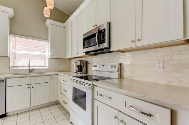 11641 Branch Mooring Dr, Tampa, FL 33635 - kitchen with appliances with stainless steel finishes, a sink, white cabinetry, tasteful backsplash, and light tile patterned floors