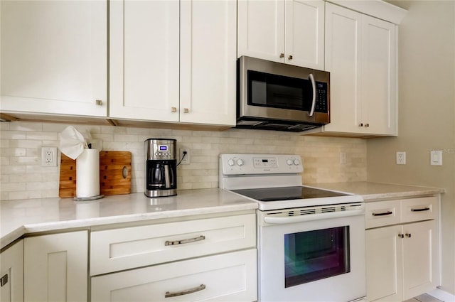 11641 Branch Mooring Dr, Tampa, FL 33635 - kitchen with stainless steel microwave, electric stove, white cabinetry, light countertops, and tasteful backsplash