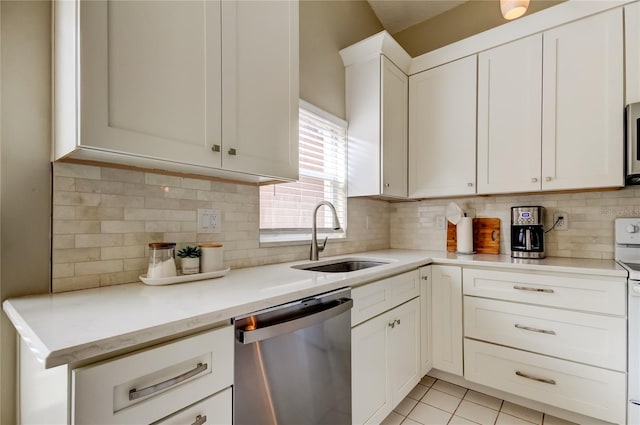 11641 Branch Mooring Dr, Tampa, FL 33635 - kitchen featuring stainless steel appliances, a sink, tasteful backsplash, light tile patterned floors, and white cabinetry