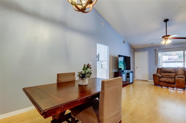 11641 Branch Mooring Dr, Tampa, FL 33635 - dining area featuring light wood-style floors, high vaulted ceiling, a chandelier, a ceiling fan, and baseboards