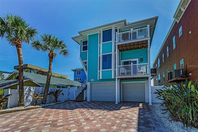 13303 Gulf Ln, Madeira Beach, FL 33708 - view of front facade featuring a balcony, an attached garage, and decorative driveway