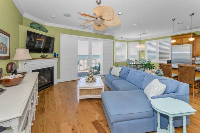 13303 Gulf Ln, Madeira Beach, FL 33708 - living area with ornamental molding, a glass covered fireplace, light wood-style flooring, recessed lighting, and ceiling fan
