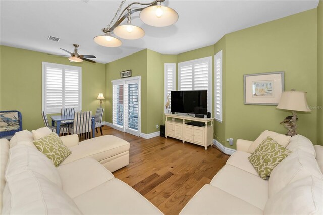 13303 Gulf Ln, Madeira Beach, FL 33708 - living room with wood finished floors, healthy amount of natural light, ceiling fan, and baseboards