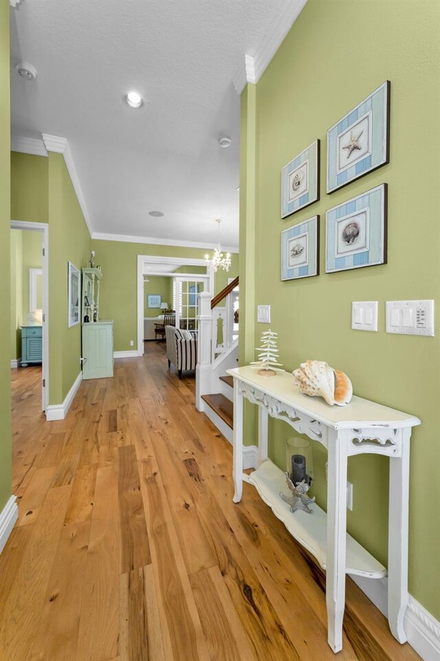 13303 Gulf Ln, Madeira Beach, FL 33708 - hallway featuring ornamental molding, a chandelier, light wood finished floors, baseboards, and recessed lighting