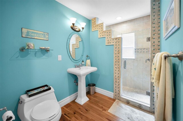 13303 Gulf Ln, Madeira Beach, FL 33708 - full bathroom featuring toilet, baseboards, a shower stall, and wood finished floors