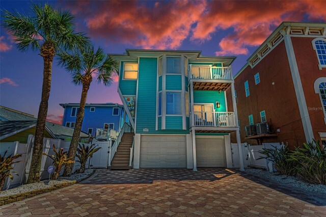 13303 Gulf Ln, Madeira Beach, FL 33708 - view of front of house with a balcony, a garage, decorative driveway, a gate, and cooling unit