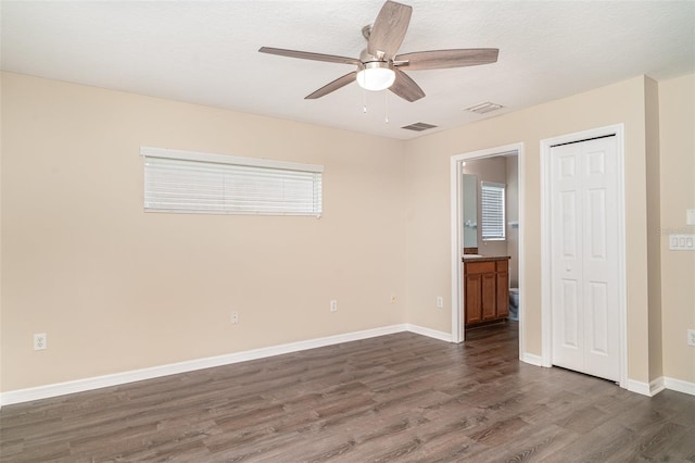 6920 Towering Spruce Dr, Riverview, FL 33578 - unfurnished bedroom with dark wood-type flooring, baseboards, ensuite bathroom, ceiling fan, and a closet