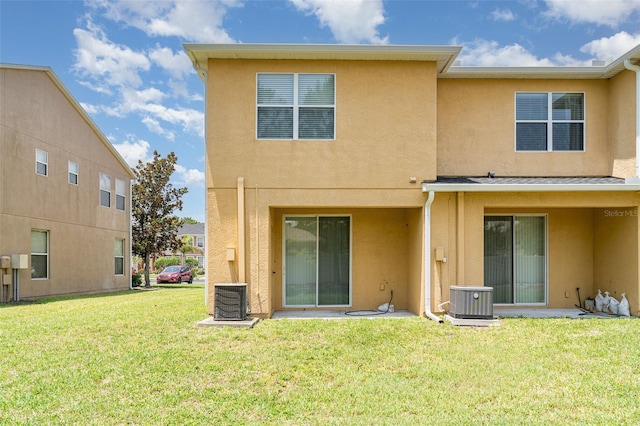 6920 Towering Spruce Dr, Riverview, FL 33578 - back of house featuring stucco siding, a lawn, and central AC