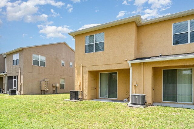 6920 Towering Spruce Dr, Riverview, FL 33578 - rear view of house featuring central AC unit, stucco siding, and a lawn