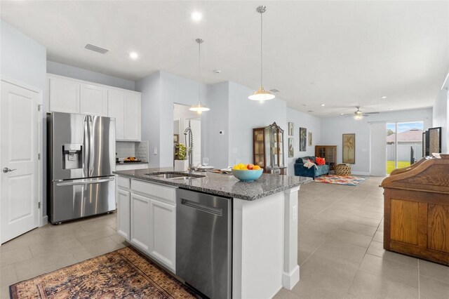 10945 High Noon Trl, Parrish, FL 34219 - kitchen with appliances with stainless steel finishes, a sink, dark stone countertops, a ceiling fan, and white cabinetry