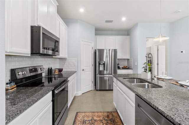 10945 High Noon Trl, Parrish, FL 34219 - kitchen featuring stainless steel appliances, a sink, white cabinetry, backsplash, and dark stone counters